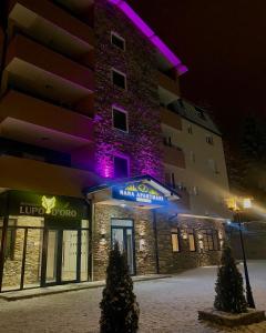 un edificio con luces púrpuras en el lateral. en Iskra na Zlataru, en Nova Varoš