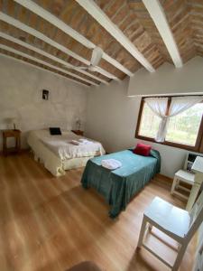 a bedroom with two beds and a chair in it at Hotel Prater in Villa General Belgrano