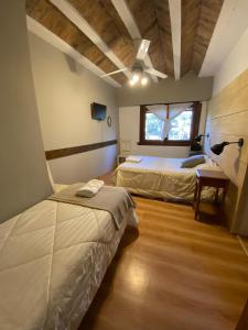 1 dormitorio con 2 camas y ventana en HOTELPRATERVGB en Villa General Belgrano