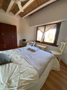 ein Schlafzimmer mit einem großen weißen Bett und einem Stuhl in der Unterkunft HOTELPRATERVGB in Villa General Belgrano