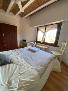 a bedroom with a large white bed and a chair at Hotel Prater in Villa General Belgrano +10 photos
