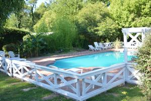 a white fence around a pool with a wooden bridge at Hotel Prater in Villa General Belgrano