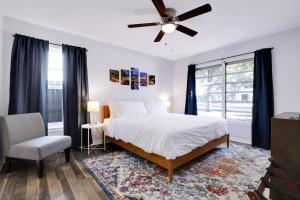 a bedroom with a bed with a ceiling fan and a chair at Texas Star - A Birdy Vacation Rental in San Antonio