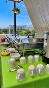 una mesa verde con platos y utensilios. en Aqua Suites, en Oaxaca City