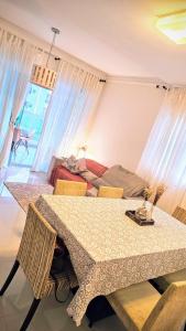 uma sala de jantar com uma mesa e um sofá em Apt Confort - Suíte c/ hidro - 9 min da praia a pé em Itapema