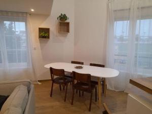 - une table et des chaises blanches dans le salon dans l'établissement L'Authentique, appart/duplex face à la gare, à Aulnay-sous-Bois