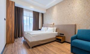 - une chambre avec un lit et une chaise bleue dans l'établissement Olympus Hotel By Umbrella, à Tbilissi