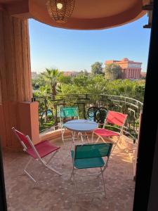 een patio met een tafel en stoelen op een balkon bij Appartement Hivernage M Avenue in Marrakesh