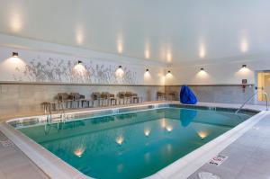 una piscina en un hotel con sillas alrededor en MainStay Suites Great Falls Airport en Great Falls
