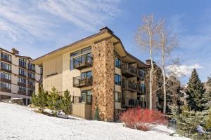 an apartment building in the snow with trees at Shadowbrook 104 in Snowmass Village