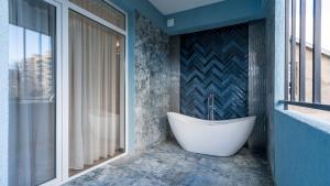 a bath tub in a bathroom with a window at Olympus Hotel By Umbrella in Tbilisi City