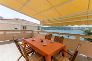 a table and chairs on a balcony with a view of the water at Apartments A-Z in Stara Novalja