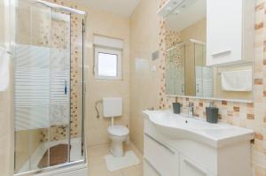 a bathroom with a toilet and a sink and a shower at Apartments A-Z in Stara Novalja +78 photos