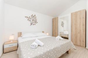 Un dormitorio con una cama blanca con toallas. en Apartments A-Z, en Stara Novalja