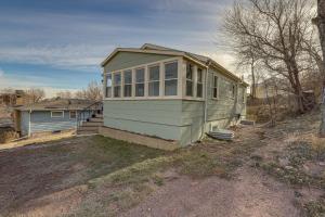 una pequeña casa verde con ventanas en un patio en Central Rapid City Vacation Rental with Sunroom! en Rapid City