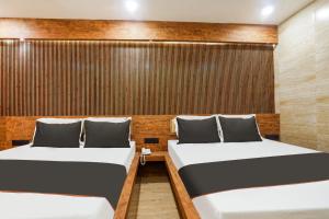 2 camas en una habitación con paredes de madera en Hotel Keys Elite, en Vijayawāda