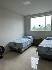1 Schlafzimmer mit 2 Betten und einem Fenster in der Unterkunft Casa Americana BD #3 in Bom Despacho