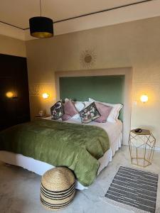 een slaapkamer met een groot bed met een groen hoofdeinde bij Appartement Hivernage M Avenue in Marrakesh