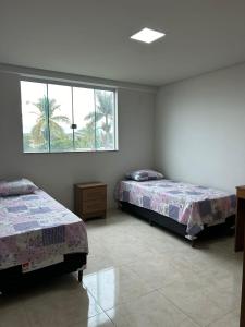 1 Schlafzimmer mit 2 Betten und einem Fenster in der Unterkunft Casa Americana BD #3 in Bom Despacho