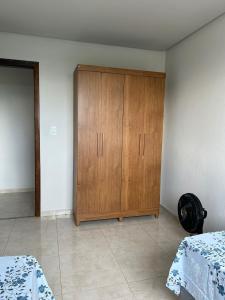 ein Schlafzimmer mit einem Holzschrank in der Ecke in der Unterkunft Casa Americana BD #3 in Bom Despacho