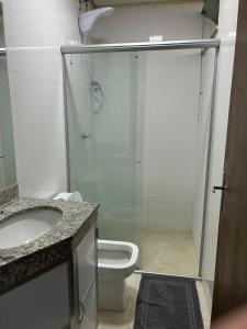 ein Bad mit einer Dusche, einem WC und einem Waschbecken in der Unterkunft Casa Americana BD #3 in Bom Despacho