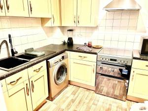 a kitchen with a washer and a sink and a stove at Peaceful Impeccable 2-Bed Apartment in Hatfield in Hatfield