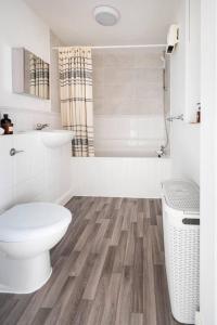 a white bathroom with a toilet and a shower at Immaculate 2-Bed Apartment in Welwyn Garden City in Welwyn Garden City