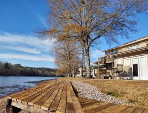 a wooden walkway leading to a house next to a lake at Lakefront Casita - Perfect for couples or families in Hot Springs
