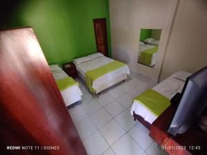 Cette chambre comprend 2 lits et un miroir. dans l'établissement Pousada Luz - Santo Amaro do Maranhão, à Santo Amaro