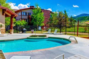 a swimming pool with two chairs and a house at The Restful Retreat in Park City