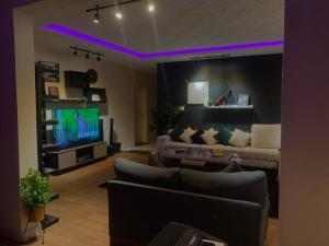 uma sala de estar com um sofá e uma televisão em شقه انيقه وموقع مميز em Dammam