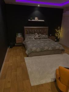 達曼的住宿－شقه انيقه وموقع مميز，一间卧室设有一张大床,拥有紫色的天花板