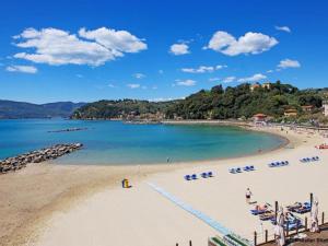 una spiaggia con sedie e persone in acqua di International Holidays Luxe House Pool Beach-Lerici-Cinque Terre-Liguria Case Vacanze in Touristic Village River ad Ameglia