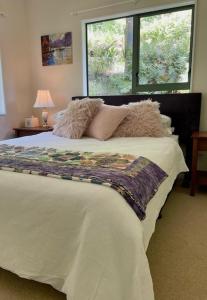 a bedroom with a large bed with a window at Annabells B&B in Whitianga