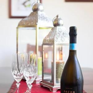 a bottle of wine and two glasses on a table at Annabells B&B in Whitianga