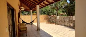 a porch with a hammock and a fence at Morada Cristal in Caraguatatuba