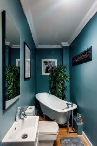 a bathroom with a tub and a toilet and a sink at Naughty Shades of Brighton in Brighton & Hove