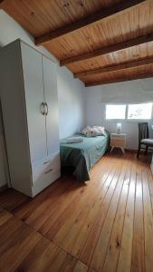 una camera con letto e pavimento in legno di Dpto en Tandil a Tandil
