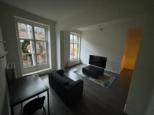 a living room with a couch and a television at Hermanos City Appartement in Enschede
