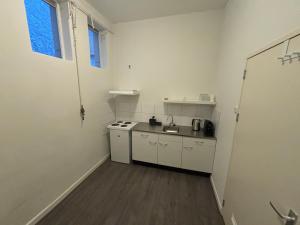 a small kitchen with white appliances in a room at Hermanos City Appartement in Enschede