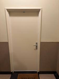 een witte deur met een zilveren handvat in een kamer bij Hermanos City Appartement in Enschede