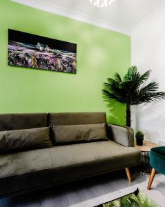 un soggiorno con divano e parete verde di 5BR House, Free Parking offA12, Contractor, Big Families, Relocation a Redbridge