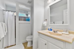 a bathroom with a sink and a toilet and a mirror at Fun, Fish, Crab - Birds, Beach & incredible Sunsets in Galveston +52 photos