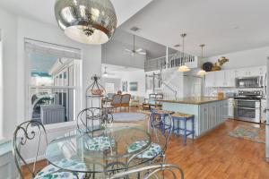 a kitchen and dining room with a glass table and chairs at Fun, Fish, Crab, Birds, Beach & incredible Sunsets in Galveston