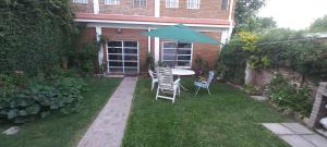 a patio with a table and chairs and an umbrella at Green House.river in Rosario