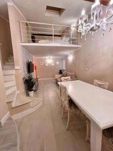 une salle à manger avec une table blanche et un salon dans l'établissement Appartamento LA TORRETTA, à Ponsacco