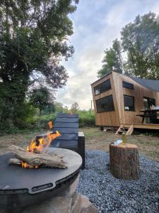 a fire pit in a yard with a house at Moose home Tiny house AMBUR in Saint-Jacques-dʼAmbur