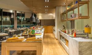 a restaurant with a counter with food on it at NH Collection Guadalajara Providencia in Guadalajara