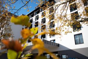 a building with yellow flowers in front of it at Infinity Hotel & Conference Resort Munich in Unterschleißheim