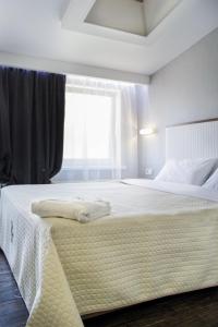 a bedroom with a large white bed with a window at Apart Hotel Kvartira 1 in Odesa